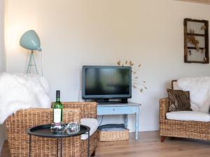 a living room with a tv and two chairs and a table at Uilenhof in Epe