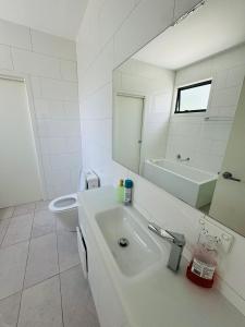 a bathroom with a sink and a toilet and a mirror at Quiet and Cozy corner in Braybrook