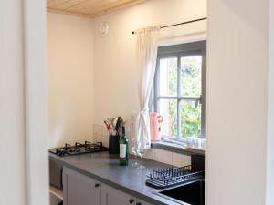 a kitchen with a stove top oven next to a window at Uilenhof in Epe