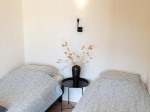 a room with two beds and a vase on a table at Uilenhof in Epe