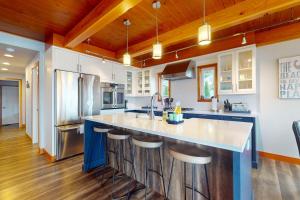 a kitchen with a large island with bar stools at Whalehouse in Tyee Beach