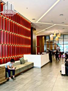 a person sitting on a couch in a lobby at The Shore Kota Kinabalu by Ems Executive Suites Seaview in Kota Kinabalu +29 photos