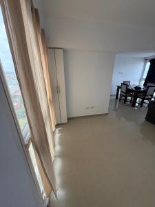 a living room with a window and a table and chairs at Edificio lillion 2 in Mar del Plata +13 photos