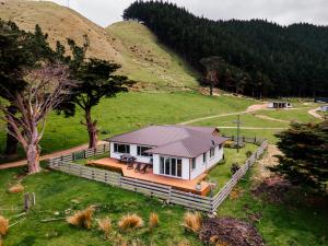a house with a roof on a green field at Arapawa Homestead in Picton