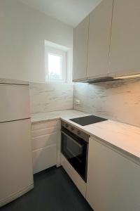 a kitchen with white cabinets and a stove and a window at Apartments with parking space Korcula - 180 in Korčula