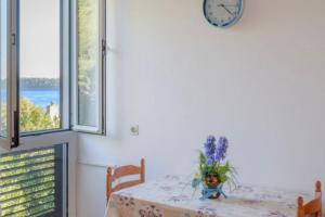 a dining room with a table with a clock on the wall at Studio Prizba 12648d in Prizba