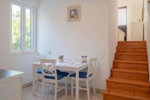 a dining room with a white table and chairs at Apartments by the sea Prizba, Korcula - 12648 in Prizba +32 photos