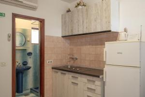 a kitchen with a white refrigerator and a sink at Apartments by the sea Prizba, Korcula - 12648 in Prizba