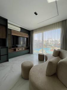 a living room with a couch and a large window at Jasmine Resort & Aqua park in Sharm El Sheikh