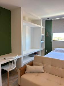 a living room with a couch and a bed at Flat com vista mar in Mucuri
