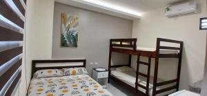 a small bedroom with two bunk beds and a desk at Suites del Pacífico in Salinas