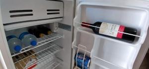 an open refrigerator with a bottle of wine in it at Suites del Pacífico in Salinas