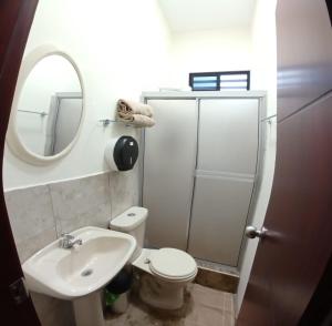 a bathroom with a toilet and a sink and a mirror at Suites del Pacífico in Salinas +54 photos
