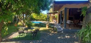 a patio with chairs and a table in front of a house at Villa Rosalía con Piscina Climatizada in Jarabacoa