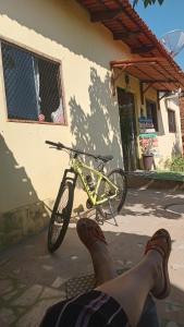 a person laying on the ground next to a yellow bike at Carolina com Ká in Carolina