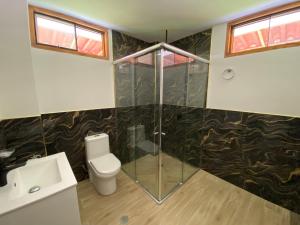 a bathroom with a shower and a toilet and a sink at La Casona - Hospedaje Campestre in El Carmen +31 photos