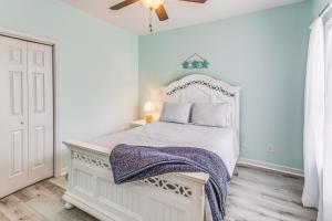 a bedroom with a white bed and a ceiling fan at Condo w/ Pool Access, 1 Mi to Cherry Grove Beach in Myrtle Beach +19 photos