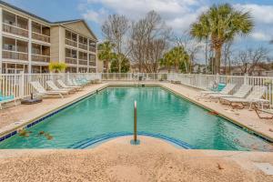 a swimming pool with lounge chairs and a resort at Condo w/ Pool Access, 1 Mi to Cherry Grove Beach in Myrtle Beach