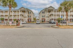 a parking lot in front of a apartment complex at Condo w/ Pool Access, 1 Mi to Cherry Grove Beach in Myrtle Beach