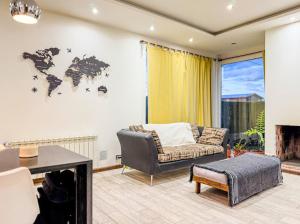 ein Wohnzimmer mit einer Couch und einer Weltkarte an der Wand in der Unterkunft OLIEMI in El Calafate