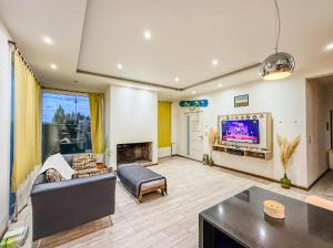 ein Wohnzimmer mit Sofa und Fernseher in der Unterkunft OLIEMI in El Calafate