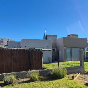 ein Haus mit einem Zaun davor in der Unterkunft OLIEMI in El Calafate