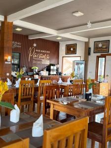 a restaurant with wooden tables and chairs and a counter at Parama Bromo Hotel in Ngadisari