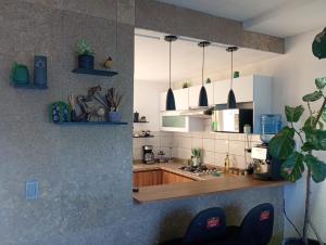 a kitchen with white cabinets and a wooden counter top at Casa Monstera Bahia in Naranjo