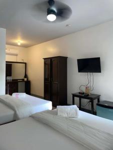 a bedroom with two beds and a flat screen tv at Garden Village Resort in Moalboal +78 photos