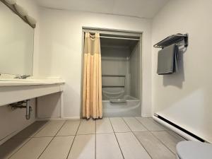 a white bathroom with a toilet and a shower at Hotel Motel La Marquise in Sherbrooke +39 photos