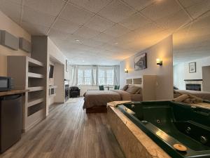 a living room with a pool table and a bedroom at Hotel Motel La Marquise in Sherbrooke