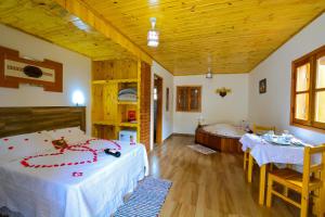a bedroom with two beds and a tub in it at Pousada Varanda Colibri in Monte Verde