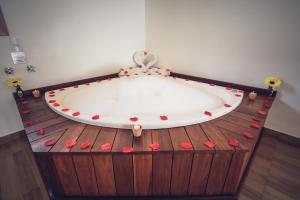 a bath tub with red hearts on a wooden floor at Pousada Varanda Colibri in Monte Verde +70 photos