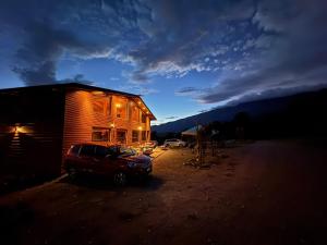 a house with a car parked in front of it at La Casona del atardecer in San Antonio de las Alzanas