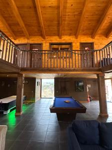 a living room with a pool table and a wooden ceiling at La Casona del atardecer in San Antonio de las Alzanas