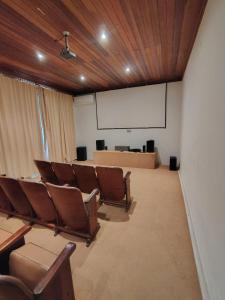 a conference room with chairs and a whiteboard and a screen at Locação temporada na Serra in Petrópolis +16 photos