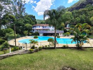 a resort with a swimming pool and a house at Locação temporada na Serra in Petrópolis