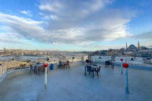 a deck with tables and chairs and a view of a city at Biter Hotel in Istanbul