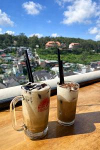 two drinks sitting on a table with a view of a city at Bình Dương Đà Lạt Hotel in Da Lat