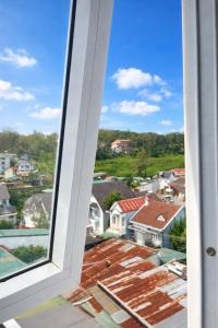 a window view of a city from a house at Bình Dương Đà Lạt Hotel in Da Lat +57 photos