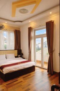 a bedroom with a bed and a large window at Bình Dương Đà Lạt Hotel in Da Lat