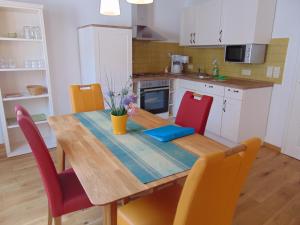 een keuken met een houten tafel en rode stoelen bij Ferienwohnung Bergblick /Moseltal in Burgen