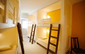 a room with three bunk beds in a room at ラナイ ホテルアンドドミトリー in Naha