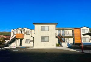 a white building with a staircase on the side of it at Sunbeam Motel in San Luis Obispo +3 photos