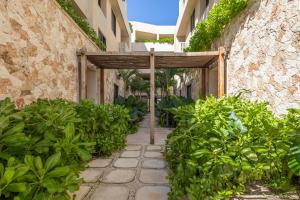 an entrance to a building with a wooden umbrella at Beachfront 2BR Condo in Bahía Tankah, Tulum in Tancah
