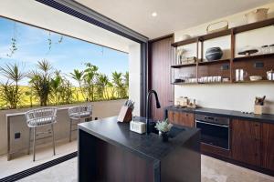 a kitchen with a large window with a patio at Beachfront 2BR Condo in Bahía Tankah, Tulum in Tancah