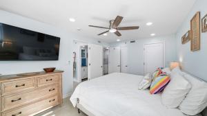 a white bedroom with a bed and a ceiling fan at Steps to the beach and amazing views! in Panama City Beach +52 photos
