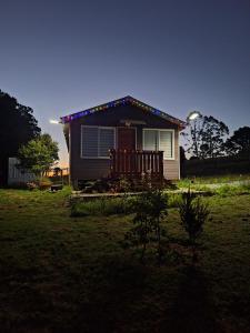 a small house with christmas lights in front of it at Cabaña ruta del canal in Calbuco
