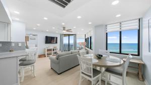 a kitchen and living room with a table and chairs at Steps to the beach and amazing views! in Panama City Beach