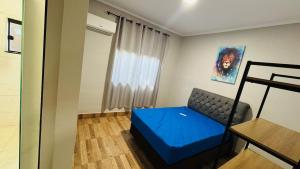 a living room with a blue couch and a window at Rancho Paradise Aruanã GO in Aruanã +30 photos